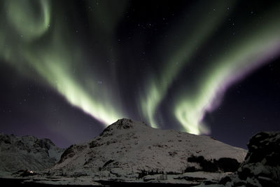 Scenic view of snowcapped mountains against sky at night