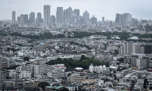 Aerial view of buildings in city against sky