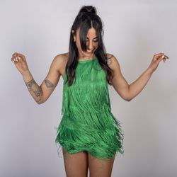 Portrait of young woman standing against white background