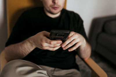 Midsection of man using mobile phone