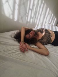 Young woman lying on bed at home