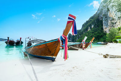 Boats moored on beach against sky