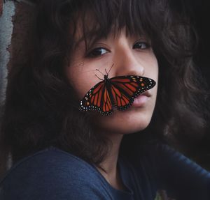 Portrait of woman holding butterfly