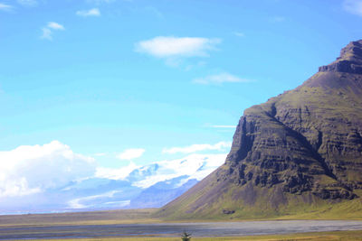 Scenic view of mountain range against cloudy sky