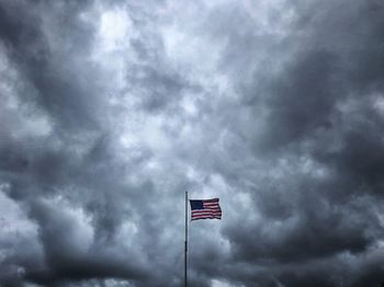 Low angle view of flag sign against sky