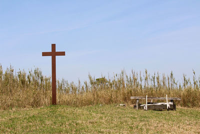 Cross on field against clear sky