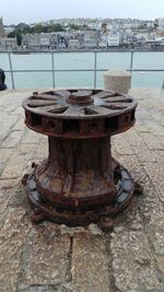 Close-up of rusty metal over sea against sky