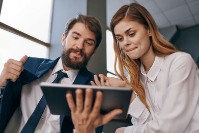 Business people talking while using digital tablet