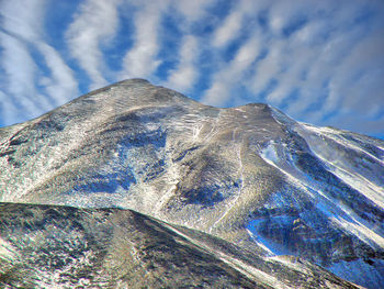 Low angle view of snowcapped mountain against sky