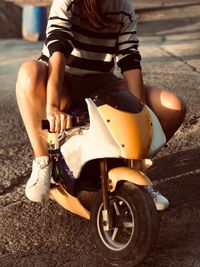 Low section of woman sitting on road