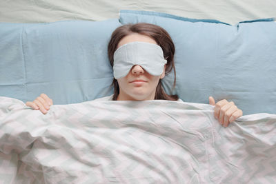 High angle view of woman sleeping on bed at home