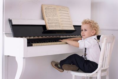 Boy playing piano indoors