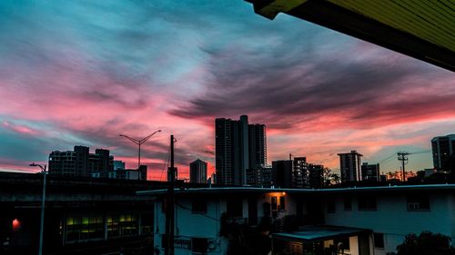 Low angle view of factory against sky during sunset