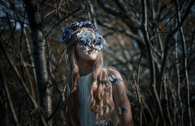 Woman wearing mask standing amidst plants