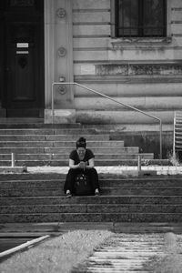 People sitting on bench against building