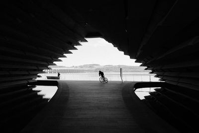 Rear view of man cycling in tunnel