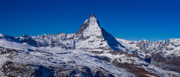 Panoramic view of snowcapped mountains against clear blue sky - matterhorn