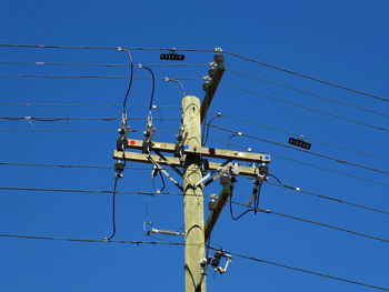 Low angle view of telephone pole against clear sky