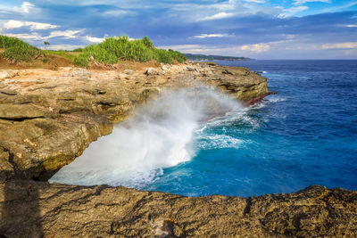 Scenic view of rocks in sea against sky