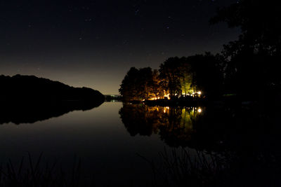 Scenic view of lake against sky at night