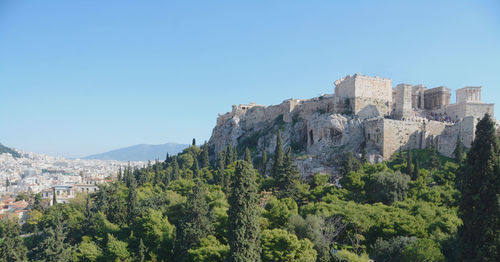 Panoramic view of trees and buildings against clear blue sky