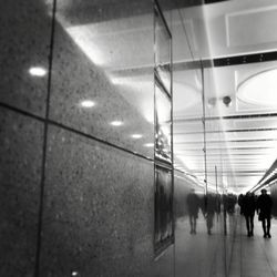 People walking in illuminated corridor