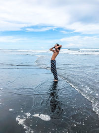 Man standing on beach against sky