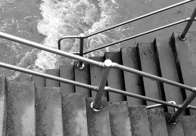High angle view of staircase with railing by sea