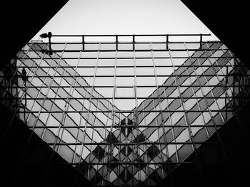 Low angle view of glass building against clear sky