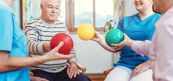 Midsection of people holding balloons