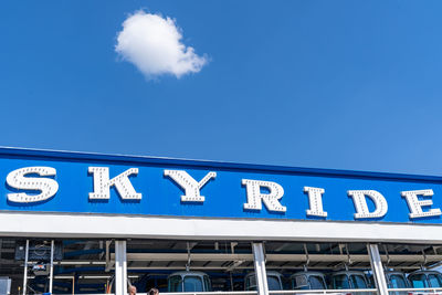 Low angle view of information sign against blue sky