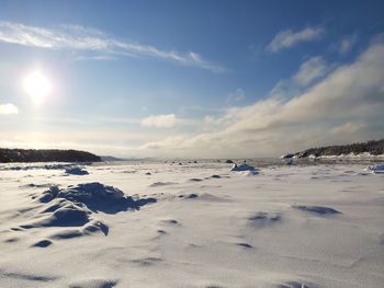 Scenic view of snow covered land against sky