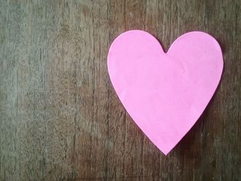 Close-up of heart shape on pink wood