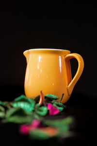 Close-up of tea cup on table against black background