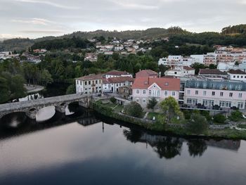 Scenic and aerial view of river by buildings against sky