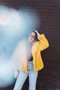 Portrait of woman standing against wall