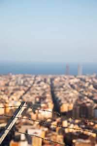 Aerial view of sea and buildings against clear sky