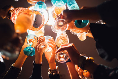 Cropped hands of friends toasting drink glasses