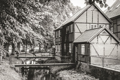 Abandoned house by lake and trees