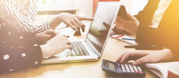 Midsection of man using laptop on table