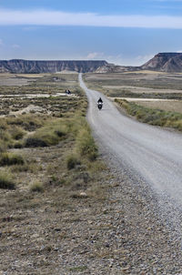 Biker driving in the natural park of bardenas reales, spain. motorcycle routes.