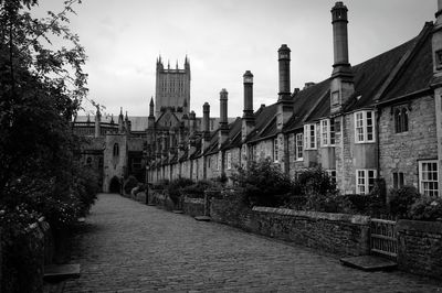 Street leading towards wells cathedral against sky