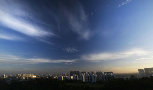 Buildings in city against cloudy sky