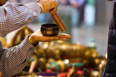 Cropped image of man playing tibetan singing bowl