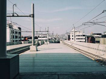 Railroad tracks in city against sky