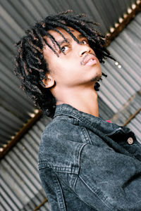 Low angle view of thoughtful young man with dreadlocks