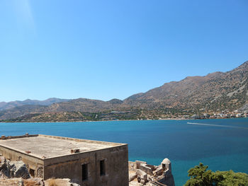 Scenic view of bay against clear blue sky