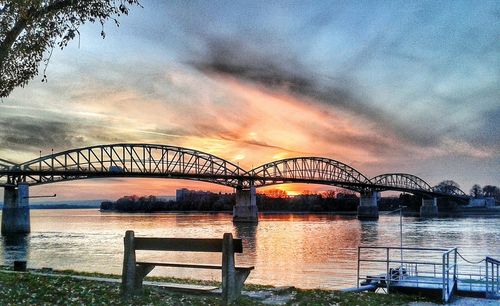 Bridge over river against sky during sunset