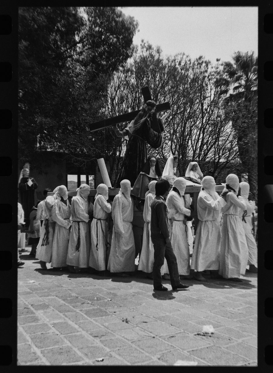 REAR VIEW OF COUPLE STANDING BY STATUE