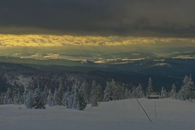 Scenic view of snow covered landscape against sky during sunset